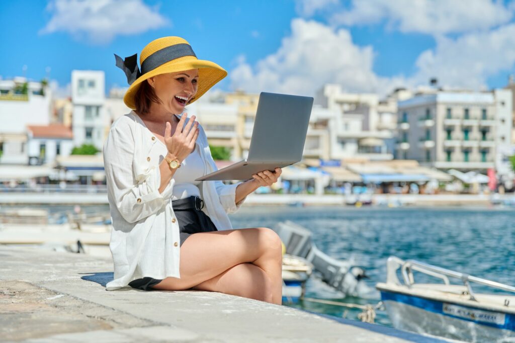 Portrait of woman in hat with laptop talking on video communication using laptop