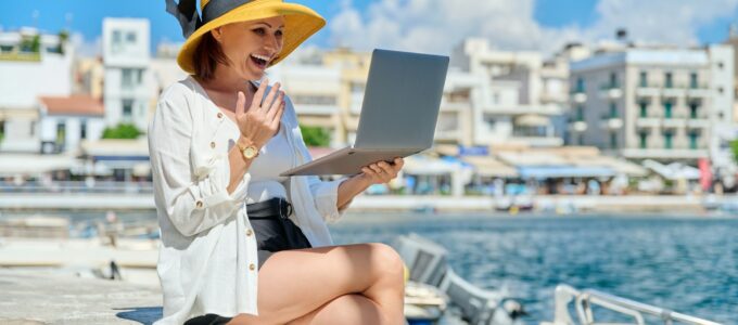 Portrait of woman in hat with laptop talking on video communication using laptop